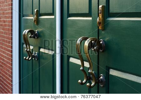 Bronze Handles Cast Shadows On The Green Door