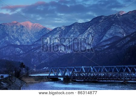 Railroad Bridge through the Carpathian Mountains, passing by the Olt Valley, Romania - sunset blue hour light