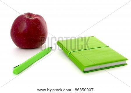 Green Notebook And Apple Isolated Over White