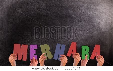 Hands holding up merhaba against black background