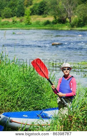 Girl near a kayak on the river