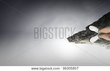 Close up of woman legs standing on the edge of rock