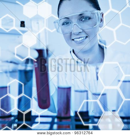 Science graphic against gorgeous redhaired female holding a test tube