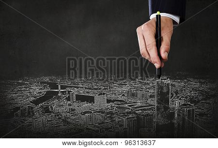 Close up of hand drawing urban city buildings