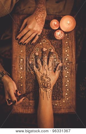 Drawing process of henna menhdi ornament on woman's hand 