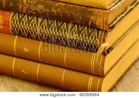 A pile of vintage books with golden touch