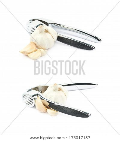 Metal garlic press utensil next to a pile of fresh cloves isolated over the white background, set of two different foreshortenings