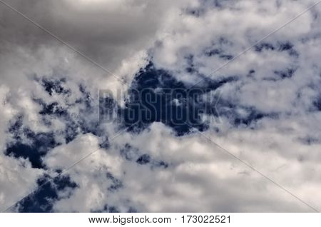 the dark blue sky with bright white relief clouds