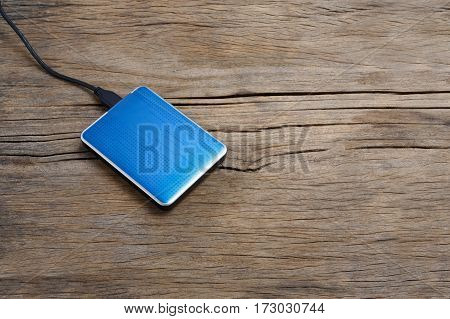 External hard drivve with USB post on wooden background