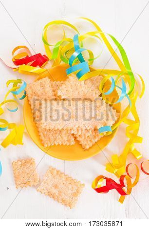 Carnival pastry with confetti on wooden table.