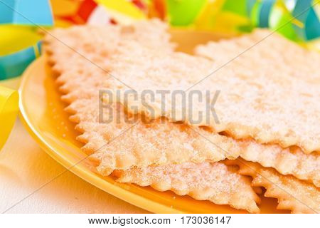 Carnival pastry with confetti on wooden table.