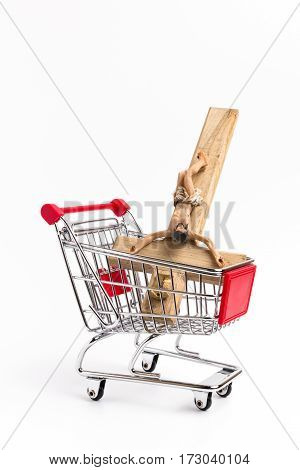 Crucifix in shopping cart. Conceptual representation of commodification of religion loss of faith blasphemy.
