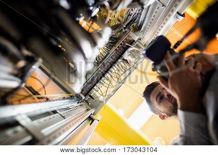 Technician using digital cable analyzer in server room
