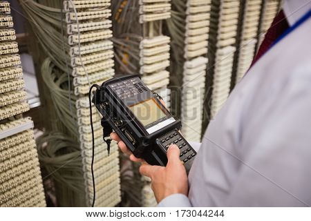 Technician using digital cable analyzer in server room