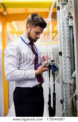 Technician using digital cable analyzer in server room
