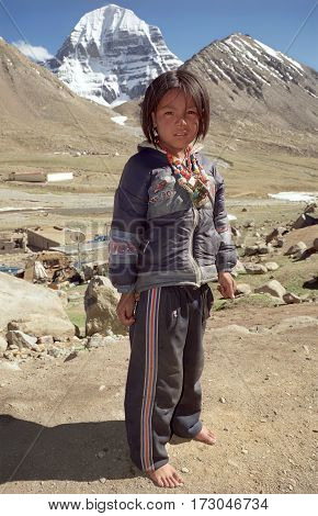 Ngary, Tibet, China - June 2011: Tibetan pilgrims girl against the North Face of Sacred Mount Kailash on altitude about 5000 meters above sea level on June 2011 in Ngary, Tibet, China.