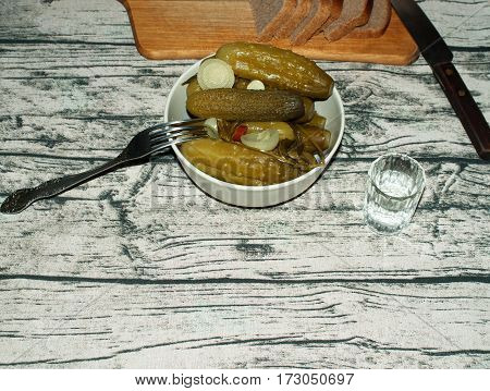 Pickled cucumbers with onion and red pepper bread glass of vodka fork knife