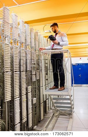 Technician using digital cable analyzer in server room