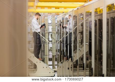 Technician using digital cable analyzer in server room
