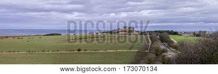Bamburgh Castle is in Northumberland on the North East coast of England it is perched on a basalt outcrop overlooking the North Sea. Close to The Farne Islands & Holy Island: Bamburgh Northumberland England UK March 15 2016.