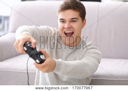 Teenager playing videogame at home
