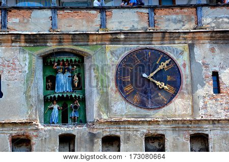 Clock in the tower of the fortress. Urban landscape in the downtown of the medieval city Sighisoara, Transylvania.