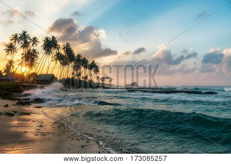Sunny beach near Koggala - Sri Lanka The area famous for its distinct stilt fishermen, who erect a single pole in the chest-deep water on the beach, just few meters off-shore. Splittoned, vivid image.