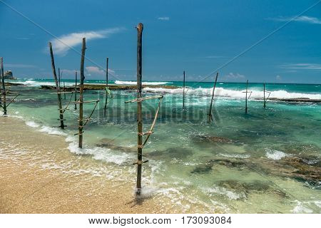Sunny beach near Koggala - Sri Lanka The area famous for its distinct stilt fishermen, who erect a single pole in the chest-deep water on the beach, just few meters off-shore. Splittoned, vivid image.