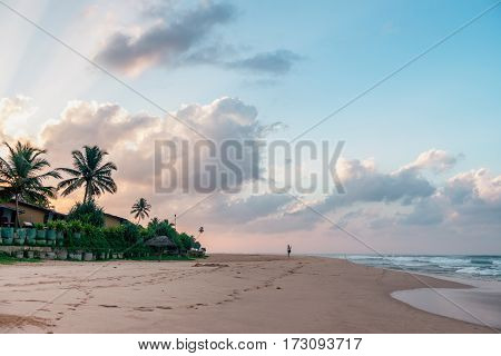 Sunny beach near Koggala - Sri Lanka The area famous for its distinct stilt fishermen, who erect a single pole in the chest-deep water on the beach, just few meters off-shore. Splittoned, vivid image.