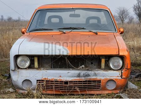 Closeup of the front part of an old abandoned car