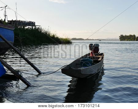 Asian long tail boat on a river lake in evening light