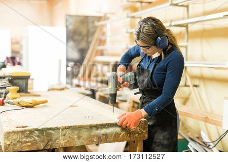 Young Woman Using A Screwdriver At Work