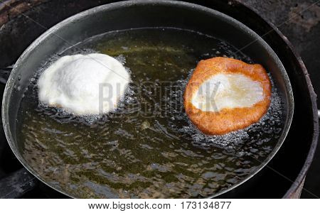 Fried Pancakes In A Pan Of Hot Oil In A Street Food Stand