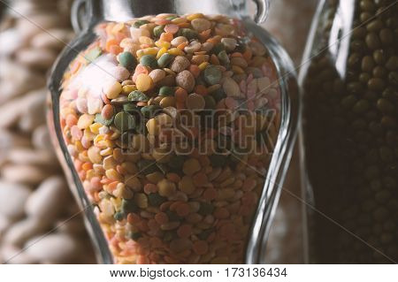 Lentils, rice, large white beans in glass jars closeup horizontal