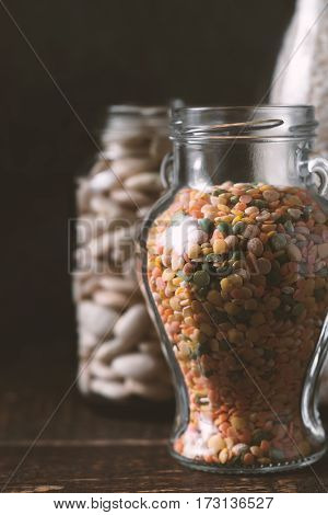 Lentils, rice, large white beans in glass jars healthy food vertical