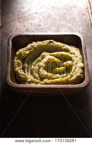 Puree beans in a wooden bowl on the table vertical