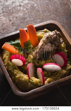 Puree beans, chicken, carrots, radishes in a bowl vertical