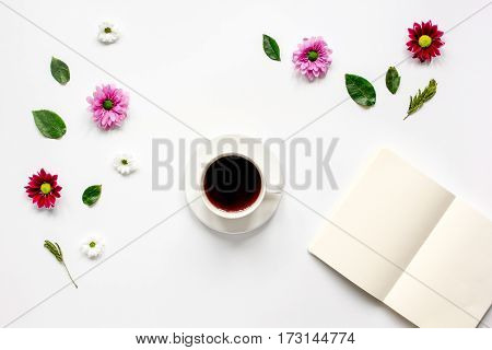 Froral flat lay with cup of coffee and craft notepaper on white background top view mockup