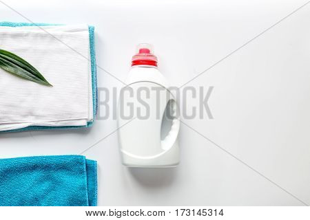 Clean towels set in laudry with plastic bottles of bleach on white table backgruond top view mock-up
