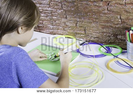 Child using 3D printing pen. Boy making new item. Creative leisure technology education concept