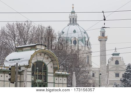 VIENNA AUSTRIA - 1ST FEB 2017: Karlsplatz station and the front of Karlskirche in central Vienna during the winter. Lots of snow and trees can be seen.