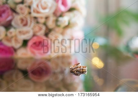 Wedding rings on the table with a bouquet