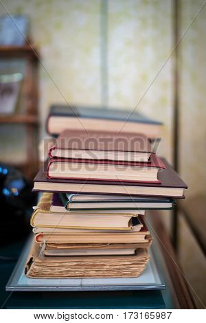 Stack of old battered books on the table.