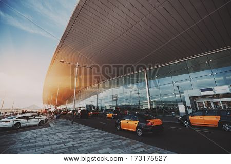 Cabstand in front of entrance of modern airport in Barcelona cabrank with a lot of taxies near glass facade of contemporary Airport terminal in Spain with road huge ceiling and parking lot