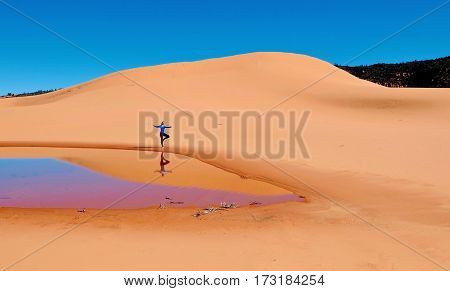 Woman doing yoga on sand dunes. Coral Pink Sand Dunes State Park. Kanab. Cedar City. Utah. United States.