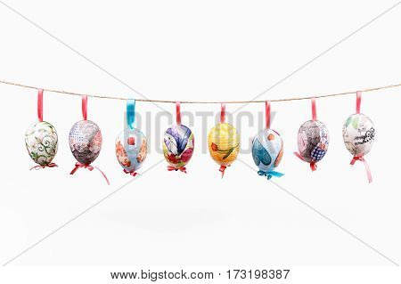 Pretty Colored Easter Eggs hanging on wire isolated on white