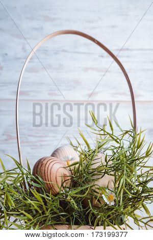 easter eggs in basket on white wooden background