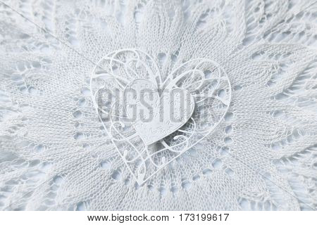 delicate still life in soft colors with paper heart on a lace napkin. soft focus.