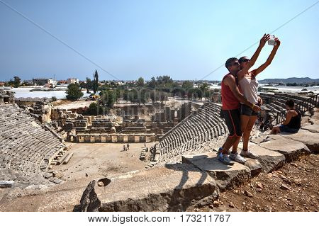 Demre Antalya Turkey - august 28 2014: Roman Theatre Xanthos Unesco World Heritage Site Lycia, young couple is doing selfie on the background of the ruins.