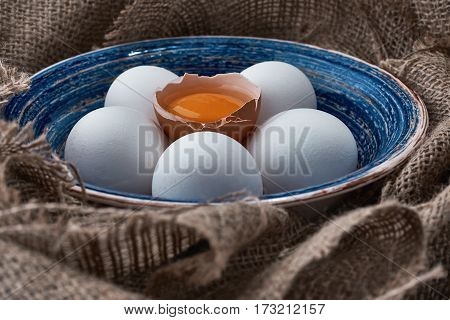 Ecological natural fresh eggs collected in the plate for cooking on the fabric.
